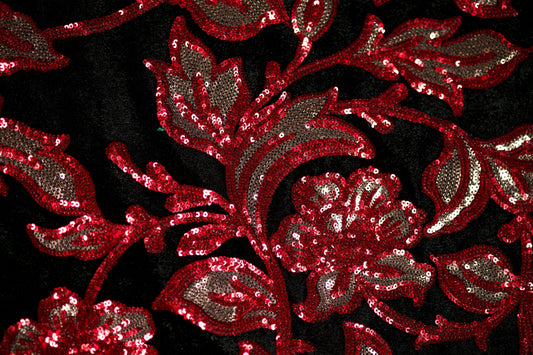 Glamouröser Stoff mit rotem Glitzer-Design auf schwarzem Samt – ideal für besondere Anlässe