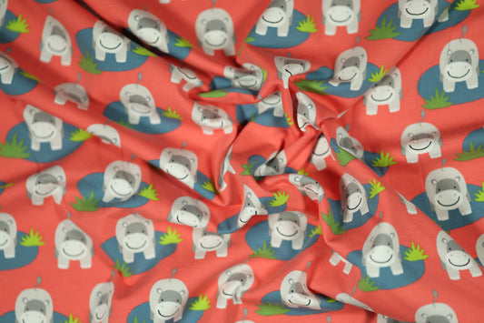 Korallroter Baumwollstoff mit einem Muster aus lustigen Nilpferden im Wasser
