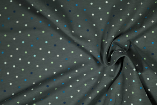 Verspielter Kinderstoff mit Punkten in Blau, Grün und Weiß.