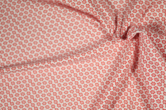 Baumwollstoff mit Motiv: rote mini-blumen auf weiß – weich & kindgerecht.