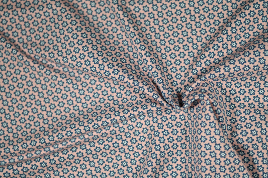 Baumwollstoff mit Motiv: blaue mini-blumen auf rosa – weich & kindgerecht.