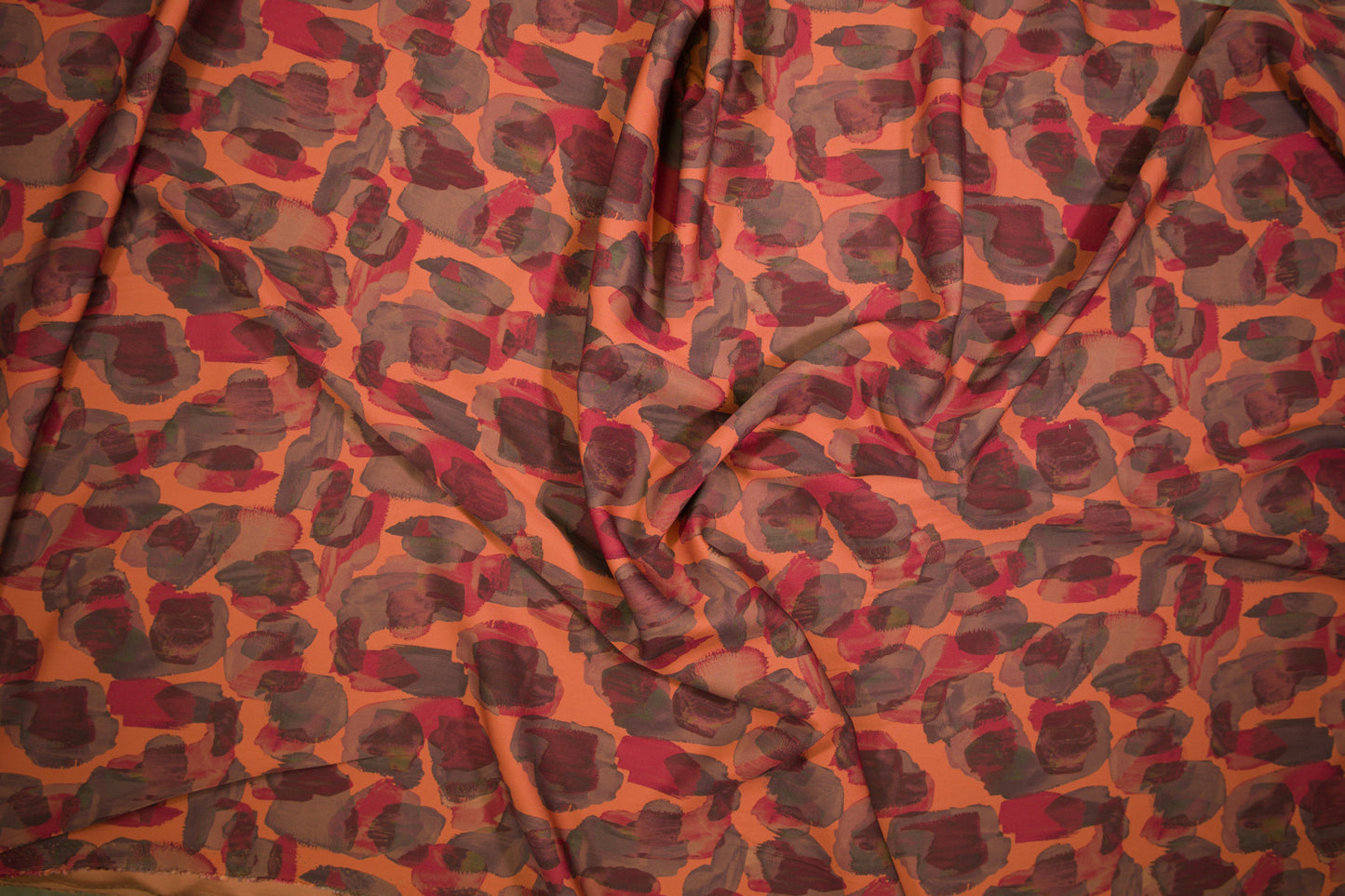 Satin Viskose mit abstraktem Animalprint in Orange und Rot Detailaufnahme der Stoffstruktur