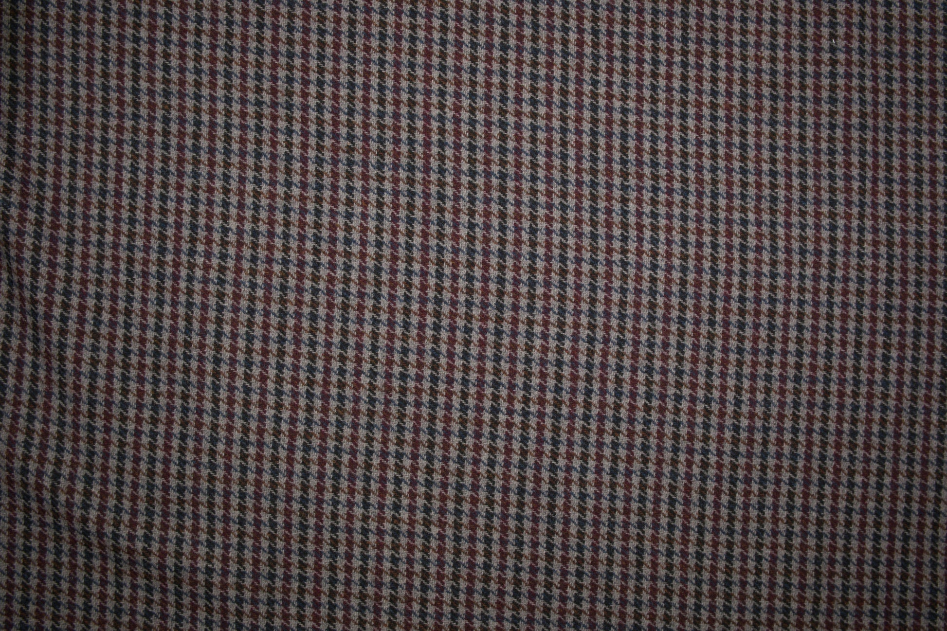 Wollstoff mit klassischem Hahnentritt-Muster in Grau, Bordeaux, Blau und Braun - Nahaufnahme der Materialqualität 140cm