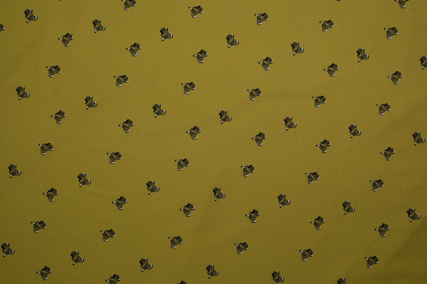 Grüner Baumwolljersey mit kleinen Hundemotiven – Detailaufnahme der Stoffstruktur