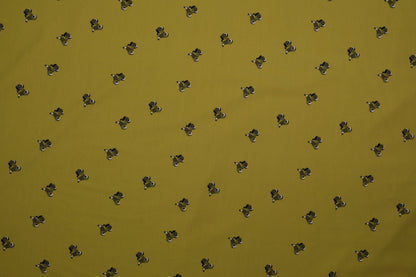 Grüner Baumwolljersey mit kleinen Hundemotiven – Detailaufnahme der Stoffstruktur