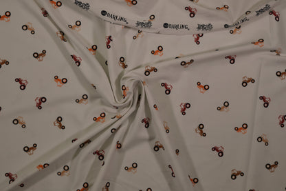 Ecrufarbener Baumwolljersey mit kleinen Traktoren – Detailaufnahme der Stoffstruktur