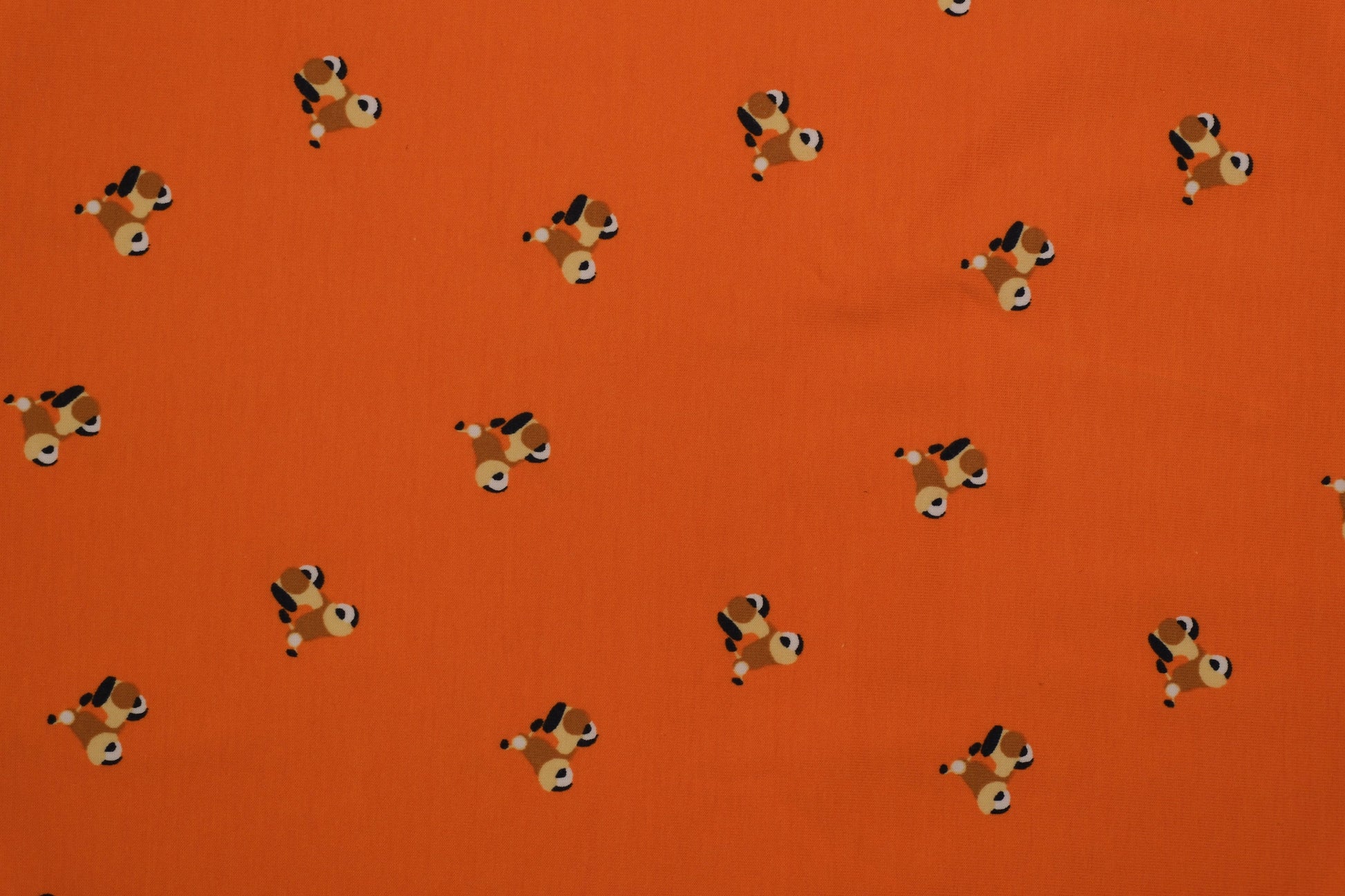 Oranger Baumwolljersey mit kleinen Hundemotiven – 140 cm breit