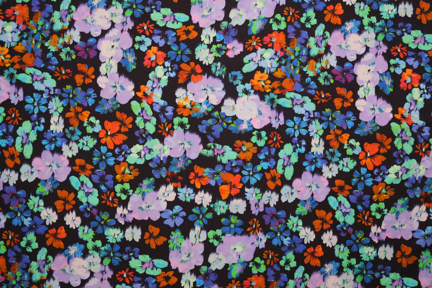 Baumwolljersey mit bunten Aquarell-Blumen auf dunklem Hintergrund – Detailaufnahme der Stoffstruktur