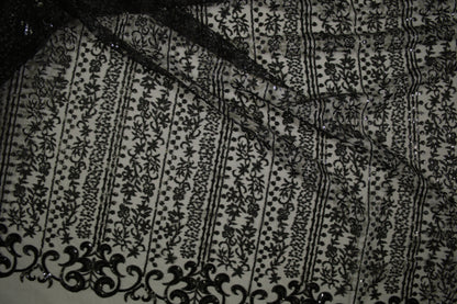 Schwarze Spitzenware auf Tüll mit floralen Streifen und Pailletten in Nahaufnahme