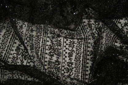 Schwarze Spitzenware auf Tüll mit floralen Streifen und Pailletten in Nahaufnahme