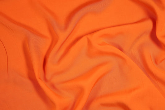 Viskosestoff in Signalorange mit fließendem Fall – perfekt für Sommermode