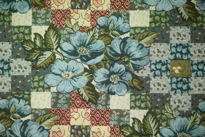 Bunter Möbelstoff mit Patchwork-Optik und blauen Blumen auf hellem Grund – perfekt für kreative Polsterprojekte